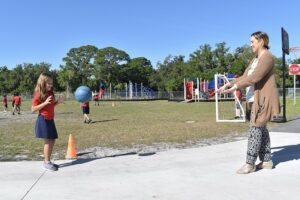 student playing abll with teacher